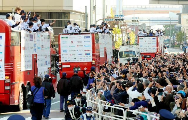 優勝パレードで、バスの上から沿道の観衆に手を振るオリックスの選手たち=2023年11月23日午後2時34分、神戸市中央区、林敏行撮影