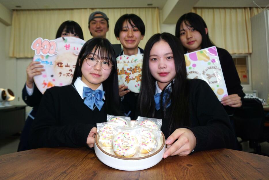 住山ごぼうのチーズケーキの商品化を喜ぶ篠山鳳鳴高生と、協力したエムズパッションの松木さん＝兵庫県丹波篠山市大熊で