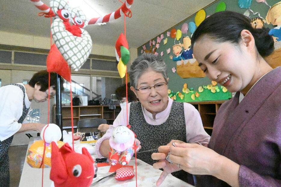 加藤央美さん（右）につるし飾りの作り方を指導する斎藤美智子さん。自身も30年ほどにわたり制作を続けている＝10日午後、東伊豆町のよりみち135