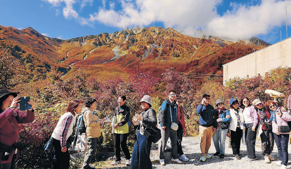 鮮やかな紅葉の景色を楽しむ観光客＝立山・黒部平