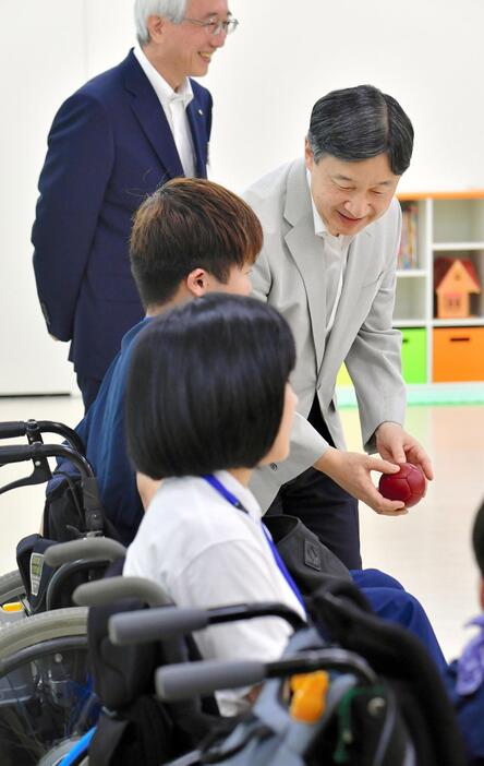 三重県立子ども心身発達医療センターを視察し、ボッチャで使う球を手渡された天皇陛下＝2018年8月、津市