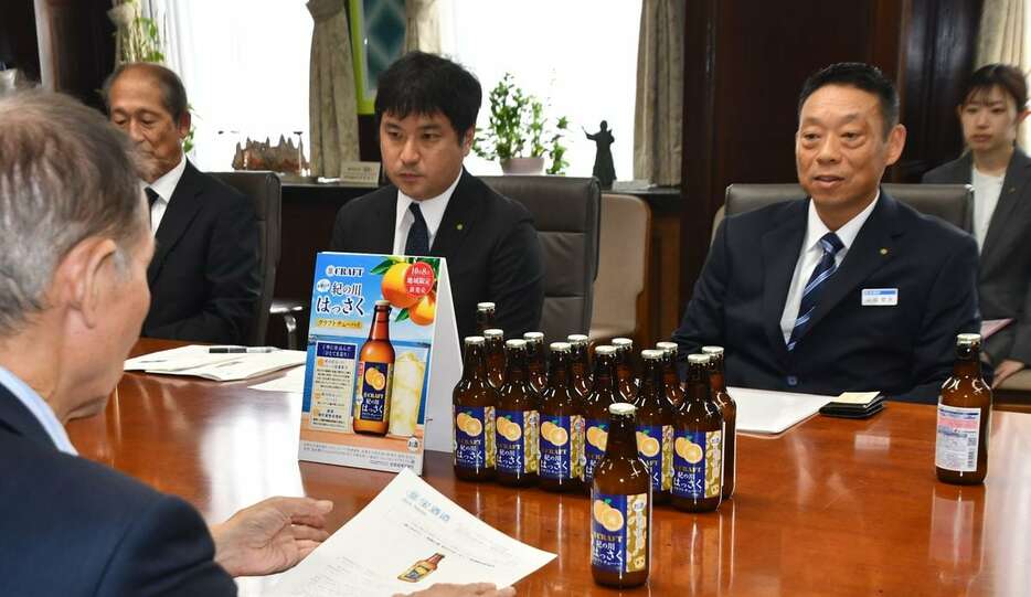 和歌山県紀の川市産ハッサクを使ったチューハイを岸本周平知事（手前）にPRする宝酒造の関係者ら＝和歌山市