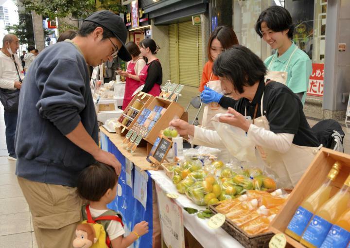 談笑しながら来場客（左）と交流を深める愛顔マルシェの出店者