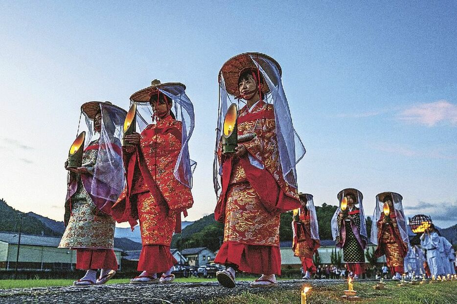 「八咫の火祭り」でろうそくに火がともされた御幸道を練り歩く時代行列の女性ら（和歌山県田辺市本宮町で）