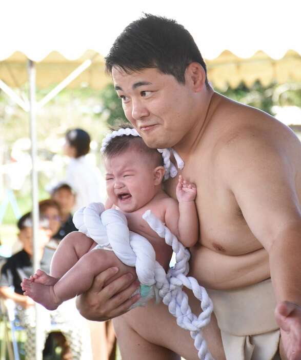 健やかな成長を祈り土俵入りする赤ちゃん＝志布志市の伊崎田小相撲場