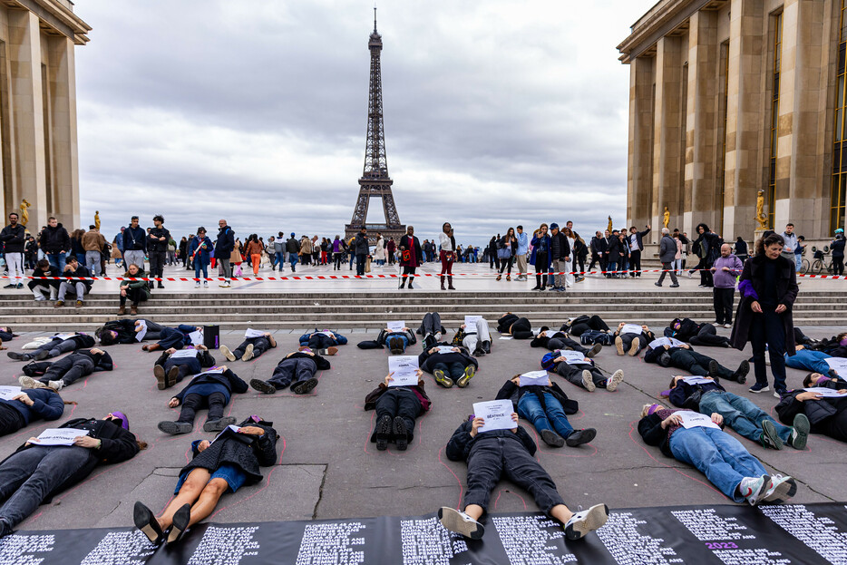 パリのエッフェル塔前のトロカデロ広場で抗議活動を行うフランスの女性団体のメンバーら。女性を狙った殺人「フェミサイド」の被害者の名前が書かれたプラカードを持って横たわり、女性に対する暴力への抗議を示した