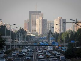 Vehicles travel along a road in Beijing. Photographer: Na Bian/Bloomberg