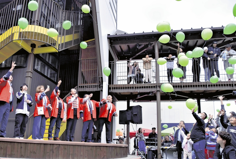 復興への願いを込めて風船を放つ参加者（鳥取県倉吉市明治町で）