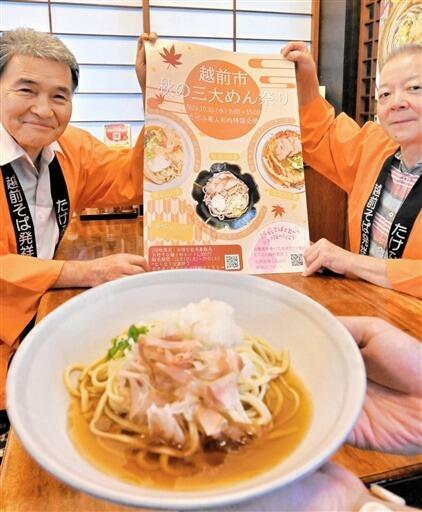 食用菊を練り込んだ越前六麦麺（手前）など「三大めん祭り」の魅力をPRする関係者=10月7日、福井県越前市内