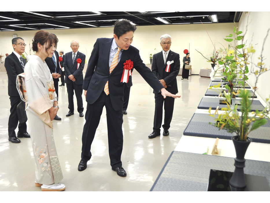 【作品を巡視する池坊雅史さん（中央）＝四日市市安島の市文化会館で】