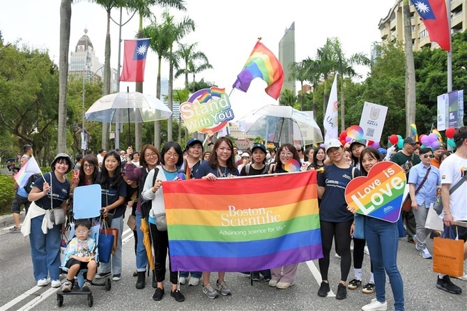 「台湾LGBT＋　プライド」で虹色の旗を手に行進する参加者＝26日、台北