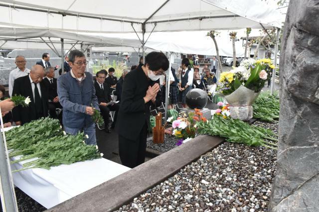 原爆死没者慰霊碑に手を合わせる参列者＝２６日午前、宮崎市・宮崎霊園