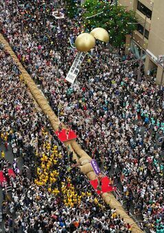 くす玉が割られ、盛り上がりが最高潮に達し始まった那覇大綱挽＝１３日午後３時５８分、那覇市・久茂地交差点