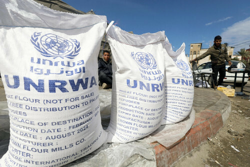 ガザ南部ラファで避難民に配られる国連パレスチナ難民救済事業機関（ＵＮＲＷＡ）の支援物資（３月７日）＝ロイター