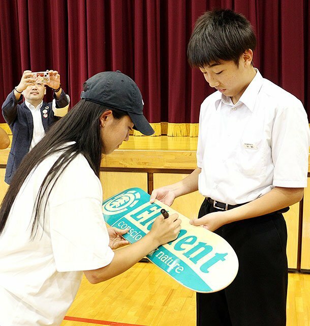 スケートボードにサインする中山選手