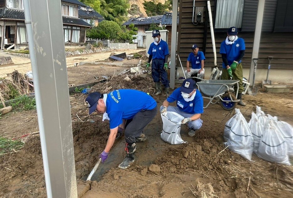 豪雨被害に遭った民家で、土砂をかき出す園部ライオンズクラブのメンバー（石川県輪島市町屋町）