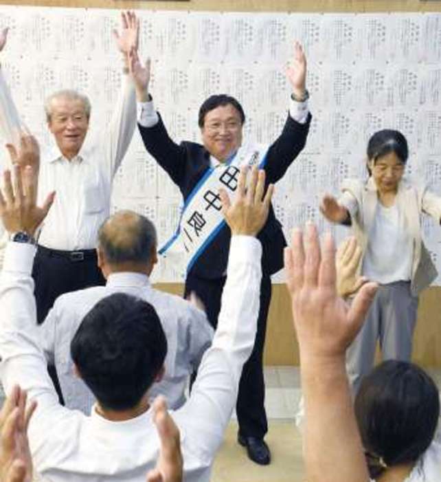 当選を祝い、支援者と万歳をする田中良二氏（中央）＝２０日午後６時ごろ、薩摩川内市西開聞町