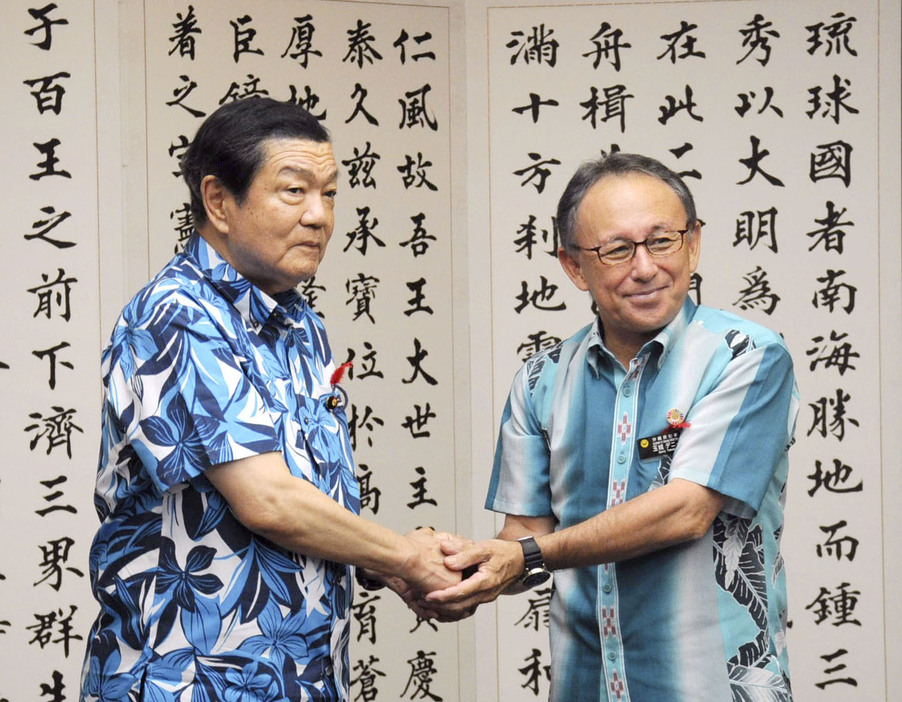 沖縄県庁を訪れ、玉城デニー知事（右）と握手する伊東沖縄北方相＝5日午後