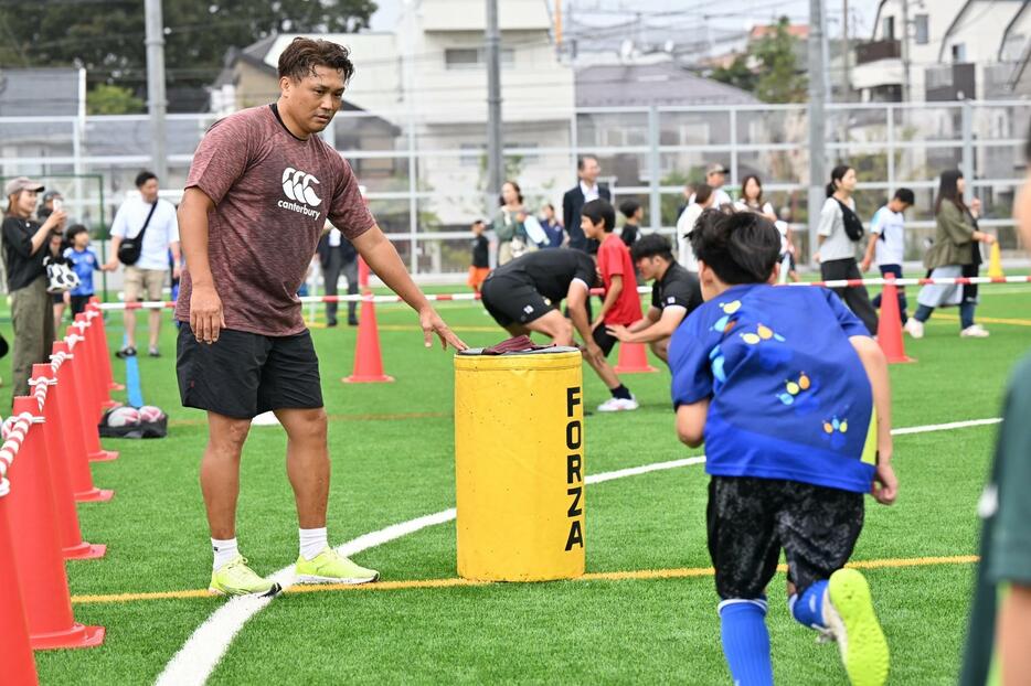 大西氏が押さえるサンドバッグに向かってタックルする子ども