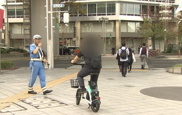 スマホを見ながらの自転車利用者を呼び止める警官