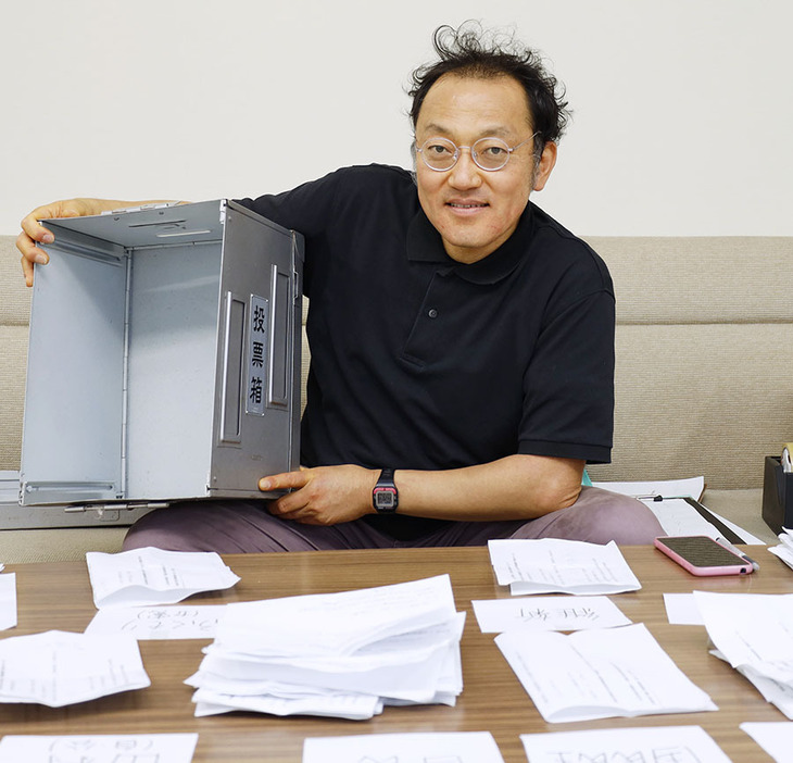 開票を終え空の投票箱の中を見せる北川さん＝市役所で