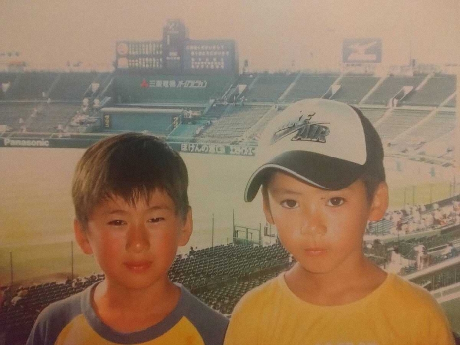 小学生の頃に兄（左）と高校野球の甲子園大会を観戦する金丸（提供写真）