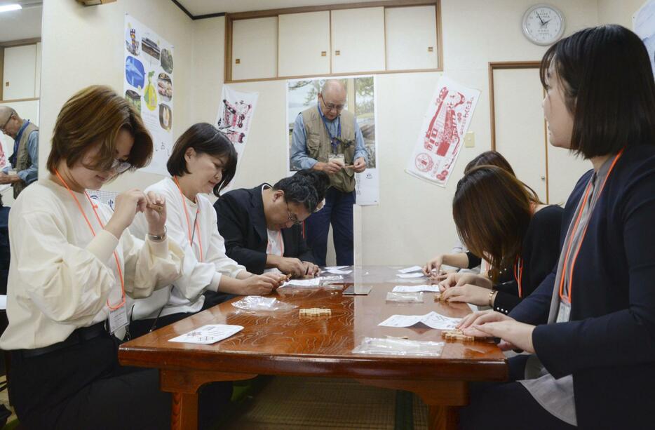 伝統工芸の木工細工の制作を体験する視察ツアーの参加者ら＝24日午後、石川県七尾市