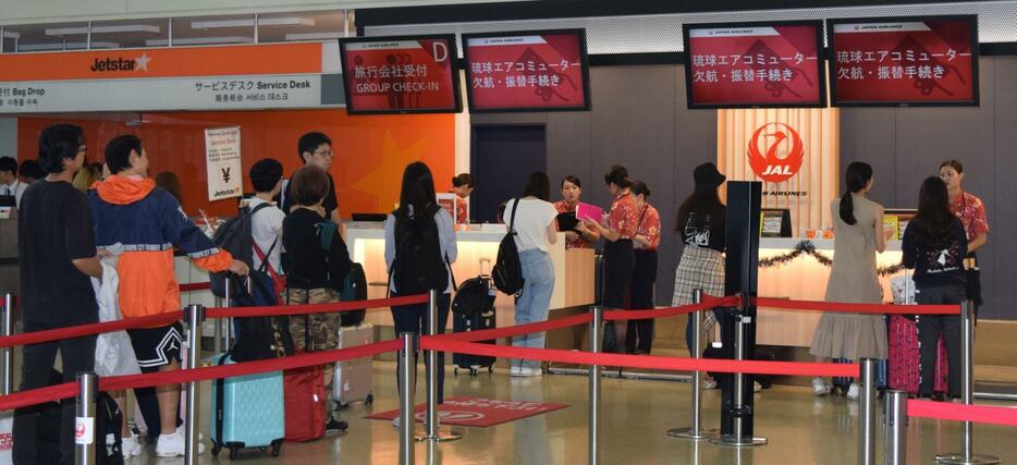 那覇空港内のRAC欠航・振替手続きカウンターに並ぶ人々＝24日午後1時半、那覇空港