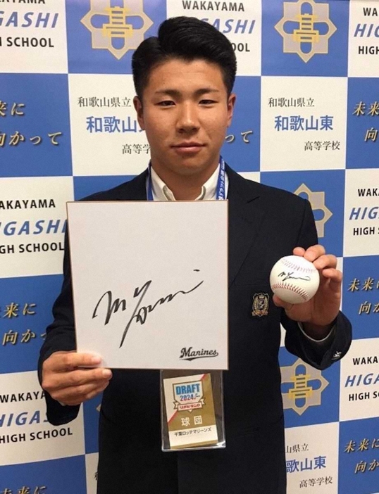 指名あいさつを受けたロッテの育成ドラフト1位・谷村は吉井監督のサイン色紙とボールを手に笑顔（球団提供）