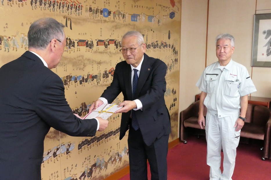 目録を手渡す田中社長=岡山県津山市で