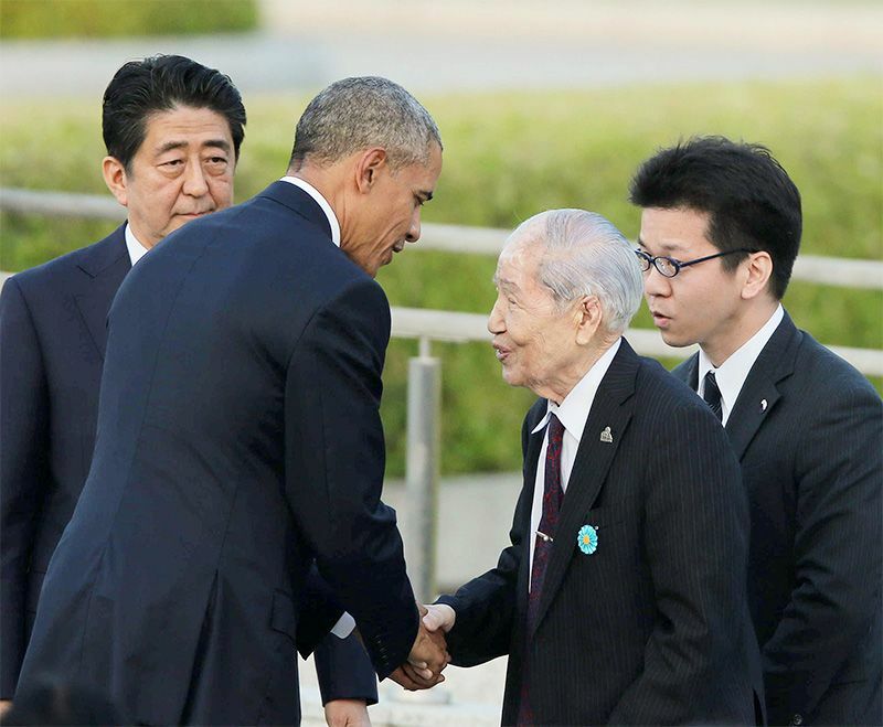 平和記念公園で、被爆者の坪井直さん（中央右）と握手し、言葉を交わす米国のバラク・オバマ大統領（同左）＝2016年5月27日、広島市中区（時事）