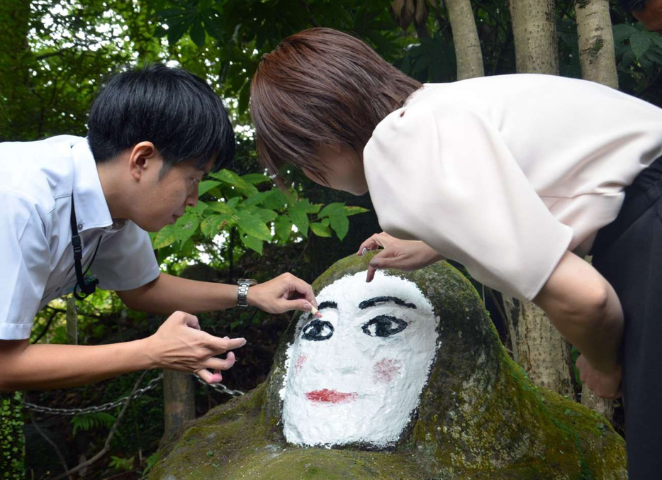 口紅を使ってピンクのアイシャドーをのせる鹿児島市職員＝４日、同市城山町