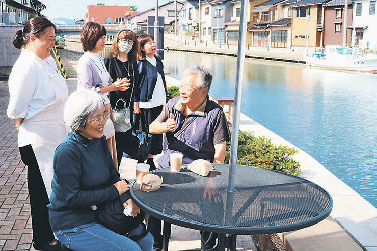 内川沿いの屋外テラスで飲食を楽しむ人たち