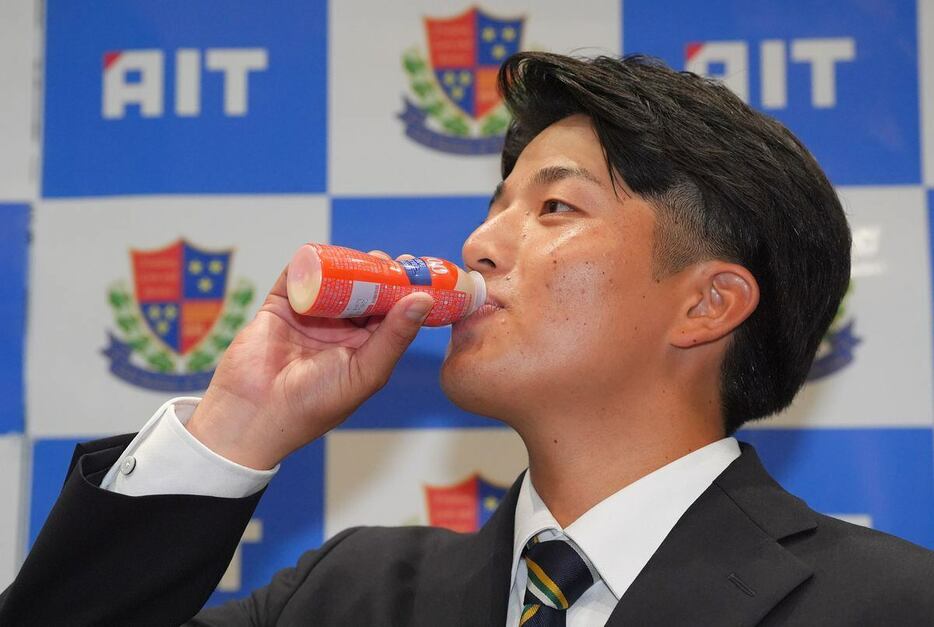 ヤクルトから1位指名され、ヤクルト1000を飲む愛知工大・中村優斗（撮影・松永渉平)