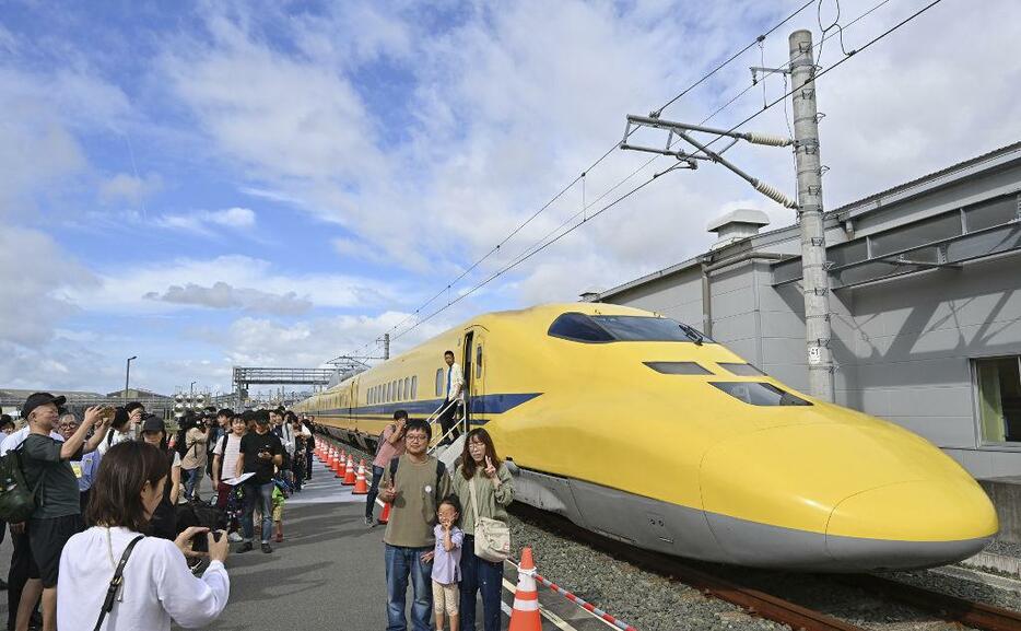 ドクターイエローの前で記念撮影する参加者＝19日午前、浜松市中央区のJR東海浜松工場