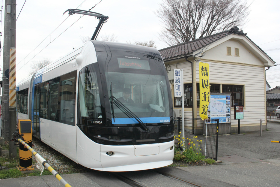 富山港線のLRT車両「ポートラム」が東岩瀬駅の旧駅舎を通過