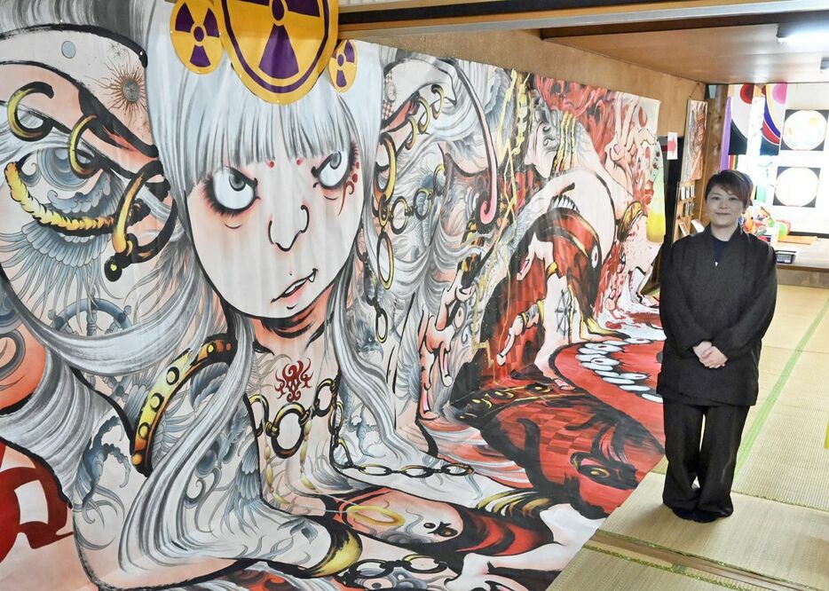 横幅が十数メートルある巨大な絵画が飾られている会場。右は白戸副住職