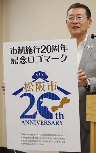 【市制20周年記念ロゴマークを披露する竹上市長＝松阪市役所で】