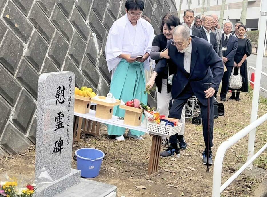 除幕された慰霊碑と、参列した草柳さん（右）＝逗子市小坪