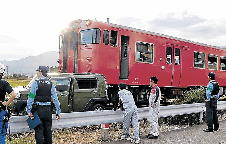 列車と衝突した車を調べる関係者＝１５日午後４時１５分、南砺市内