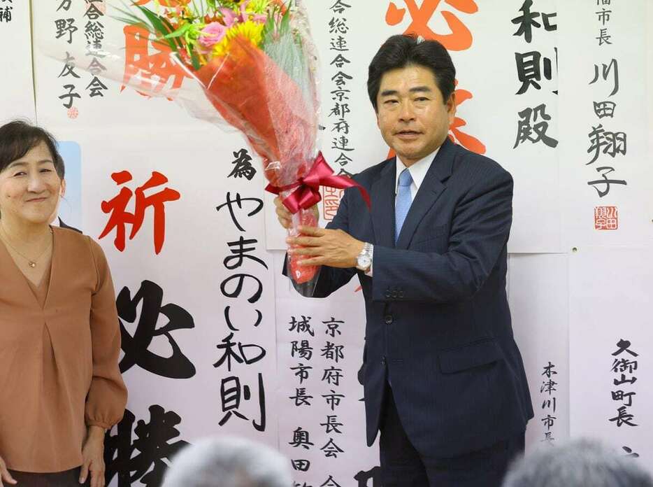 当選確実となり、花束を受け取った山井和則氏＝10月27日、京都府宇治市（渡辺大樹撮影）