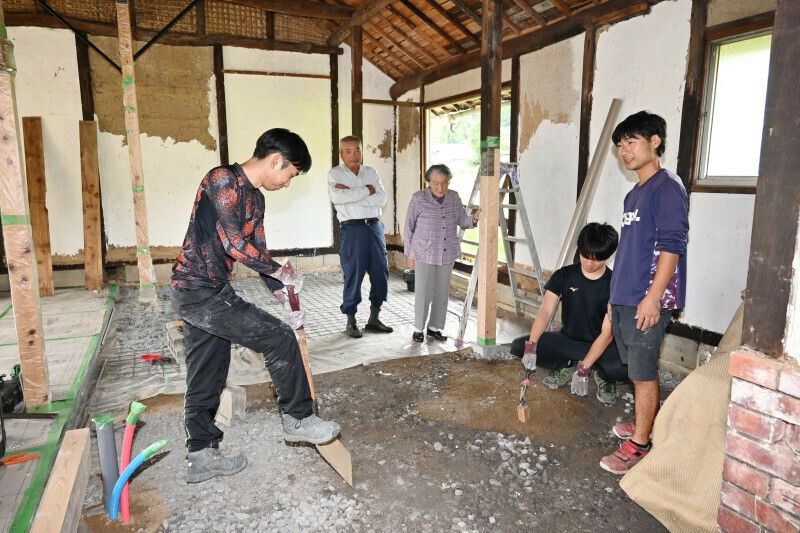 移住者向けシェアハウスなどの開設を目指して空き家を改修する岡田さん（右）と岡山理科大の学生や地元住民