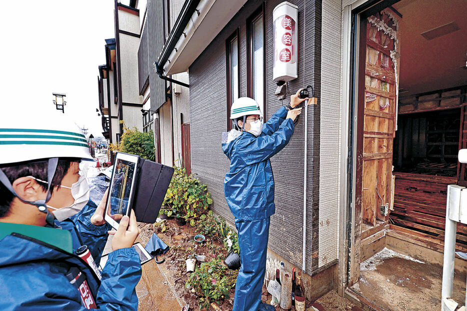 被害家屋の調査を行う三重県からの職員＝４日午前１１時２０分、輪島市河井町