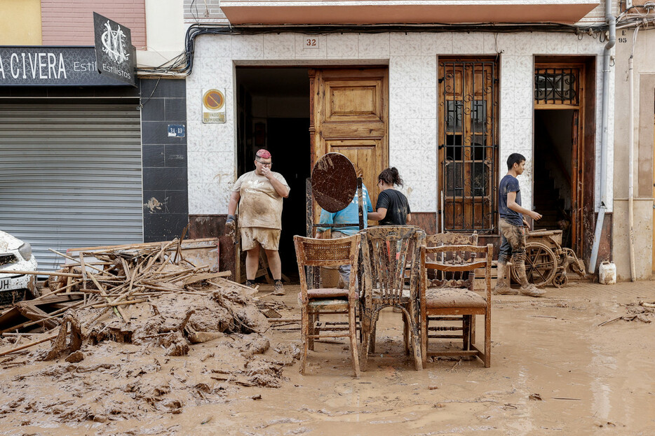 ３０日、スペイン東部バレンシア自治州パイポルタで、水に漬かった家具を運び出す住民（ＥＰＡ時事）