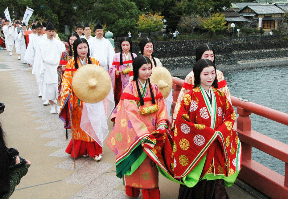 紫式部役の井上花音さん（手前）とともに宇治川を渡る平安衣装の行列＝京都府宇治市の朝霧橋で２０２４年１０月１８日午前１０時１４分、鈴木健太郎撮影