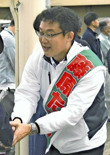 握手を交わし支持を訴える藤原氏（１５日、岩手県奥州市で）