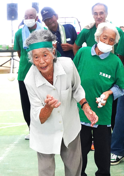 かくしゃくと「玉入れ」競技を楽しむ田尻スミエさん＝前方＝と中原範さん