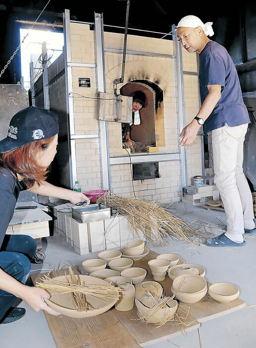 能登半島地震後初めての窯での焼成に向けて準備を進める創炎会メンバー＝２１日午前１０時半、珠洲市陶芸センター