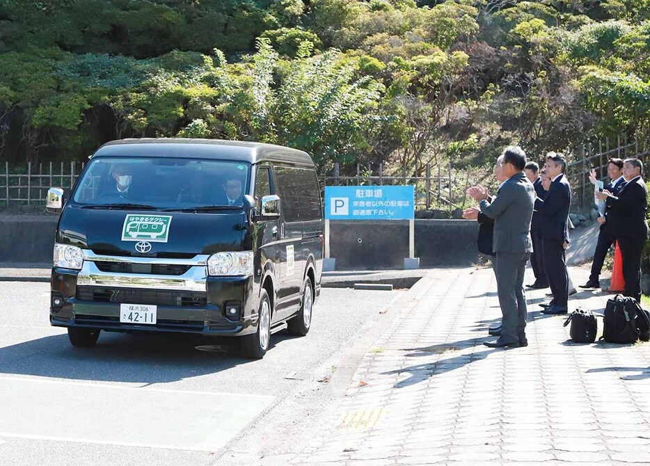 関係者に見守られて出発する「はやまるタクシー」＝２１日、葉山町役場駐車場（町提供）