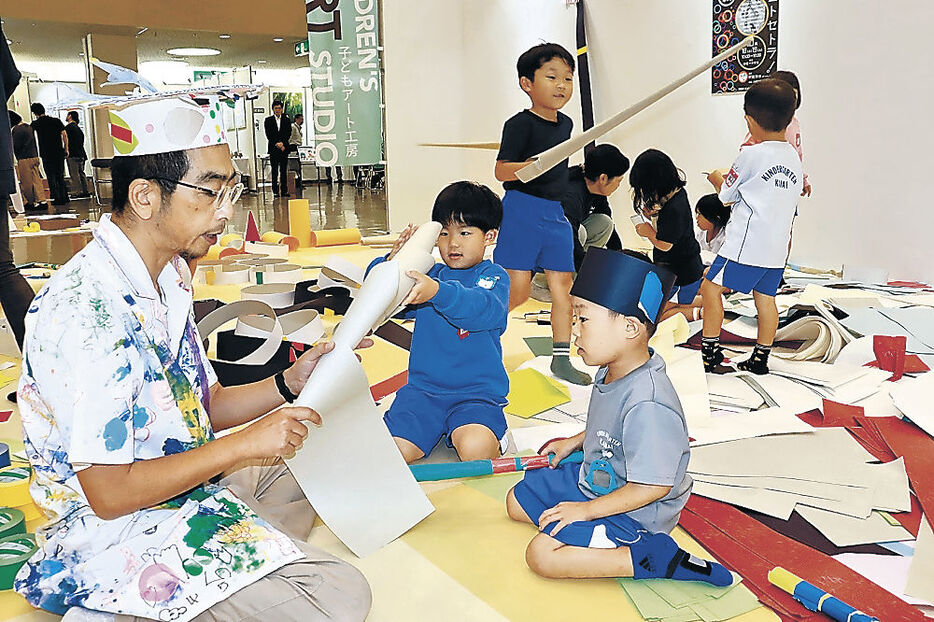 紙で工作を楽しむ園児＝１８日午前１１時１０分、金沢市の石川県産業展示館２号館